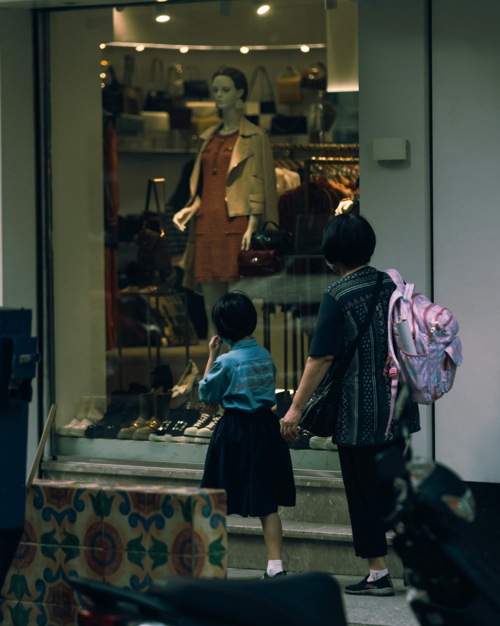 Madre eligiendo una mochila escolar junto a su hija en la tienda